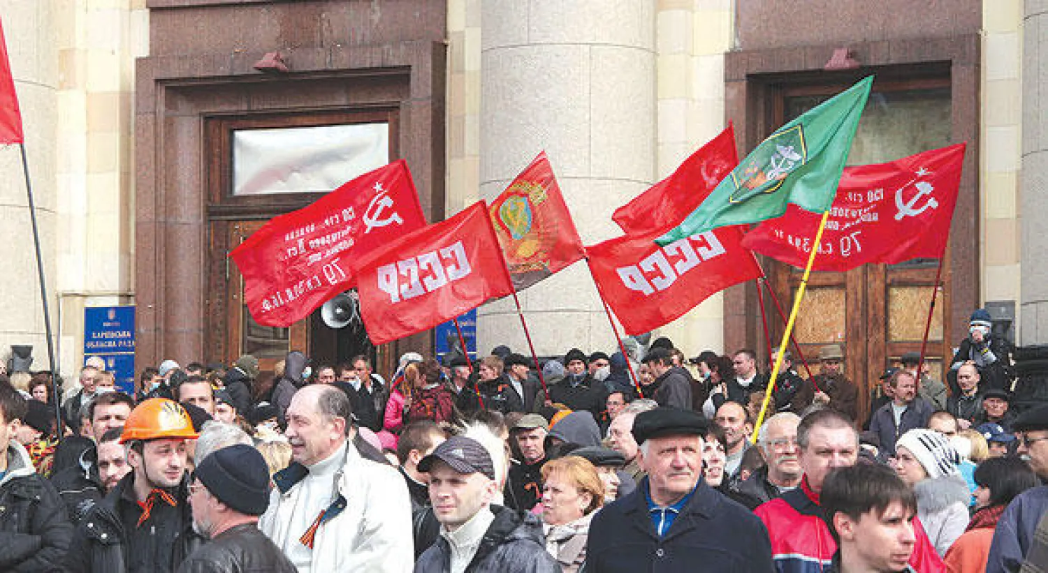 موالون لروسيا يحملون أعلاما تحمل شعار الاتحاد السوفياتي أمام مبنى حكومي في مدينة خاركيف الأوكرانية أمس (أ.ف.ب)