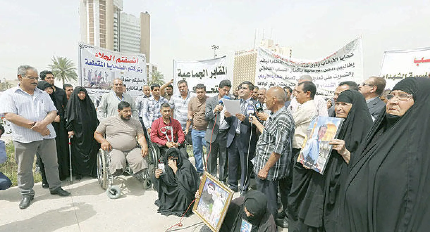 ضحايا العنف في العراق وأقاربهم يتظاهرون في بغداد أمس مطالبين بإنصافهم (أ.ف.ب)