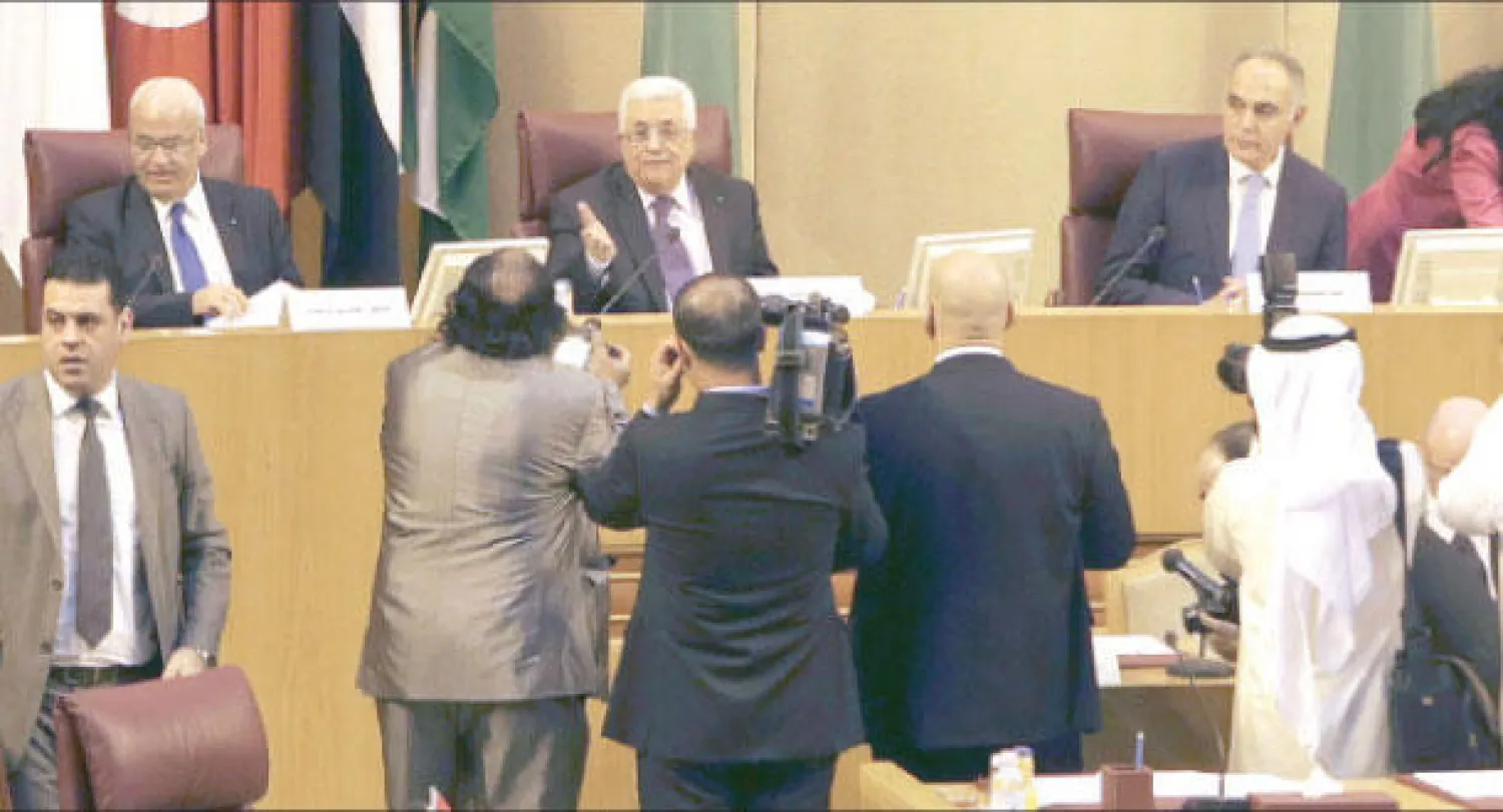 الرئيس الفلسطيني محمود عباس يتوسط صلاح الدين مزوار وزير الخارجية المغربي رئيس الدورة الحالية لمجلس الجامعة العربية وصائب ريقات كبير المفاوضين الفلسطينيين خلال اجتماع وزراء الخارجية العرب في القاهرة أمس (رويترز)