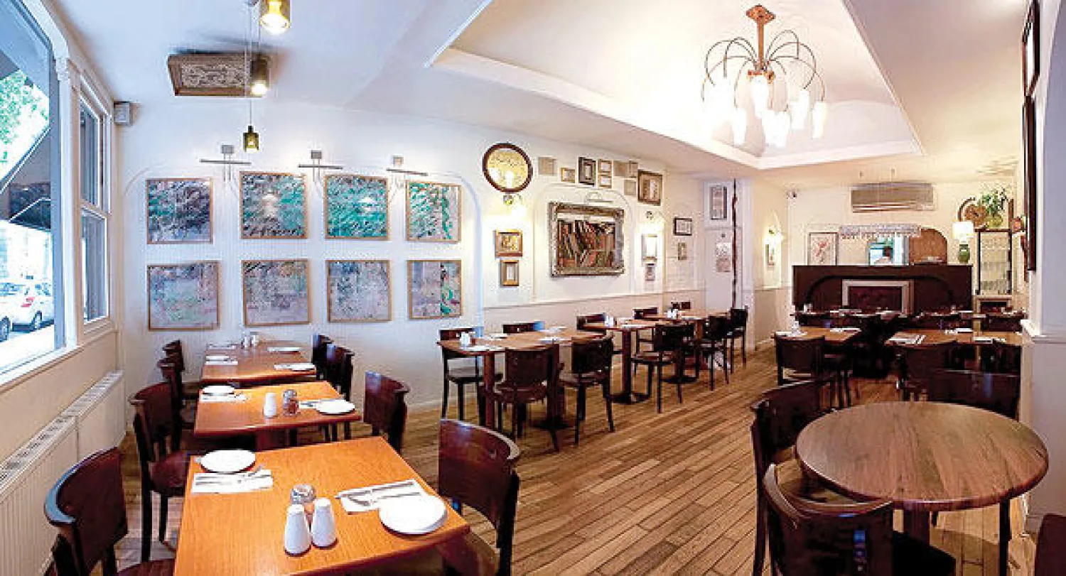 مطعم حافظ من الداخل وتبدو فيه لوحات لخطاطين ايرانيين على الحائط