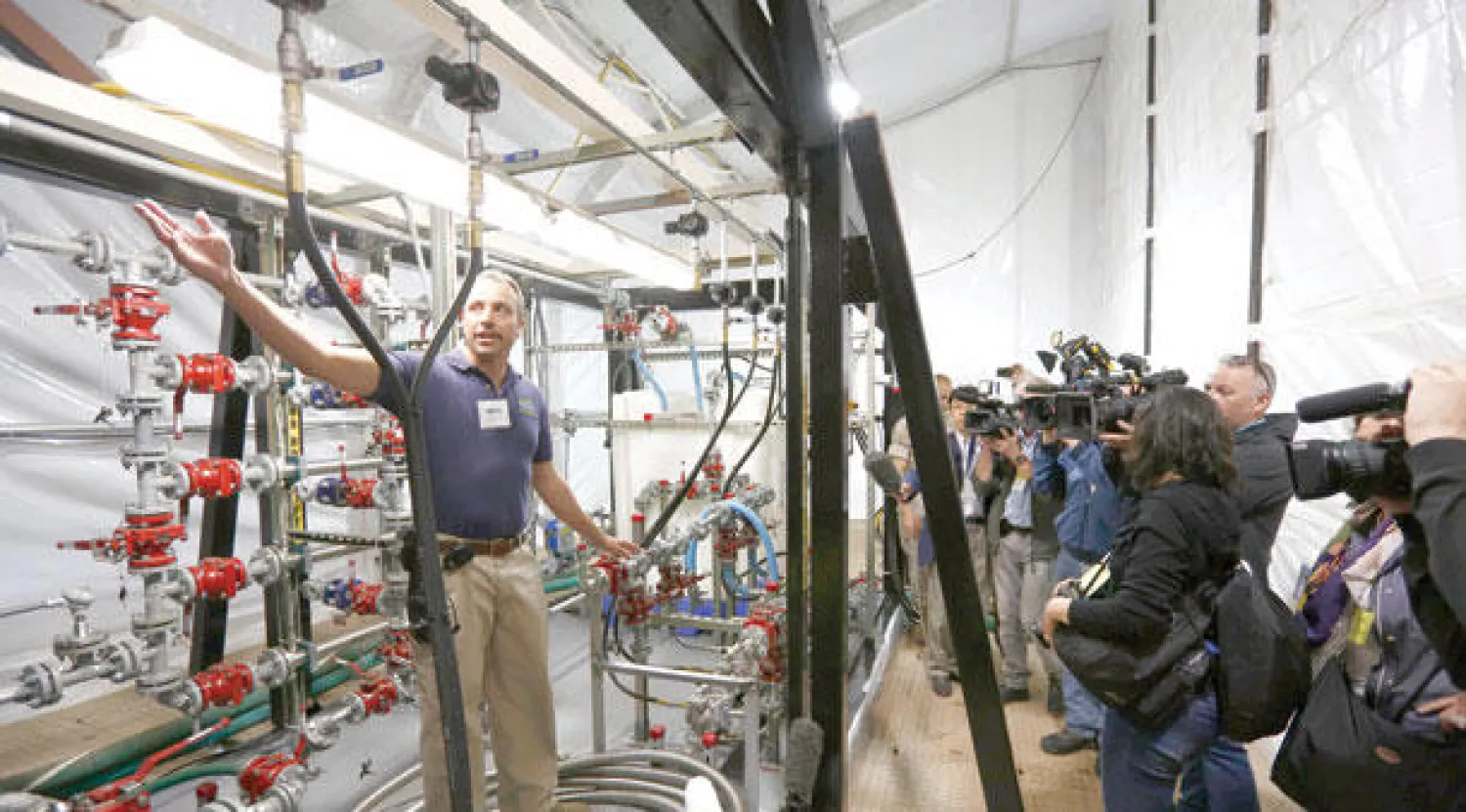 أحد أعضاء فريق الخبراء على متن السفينة «كيب راي» في مرفأ قاعدة روتا الجوية جنوب إسبانيا شارحا للصحافيين آلية تدمير مخزون الأسلحة الكيماوية السورية (رويترز)