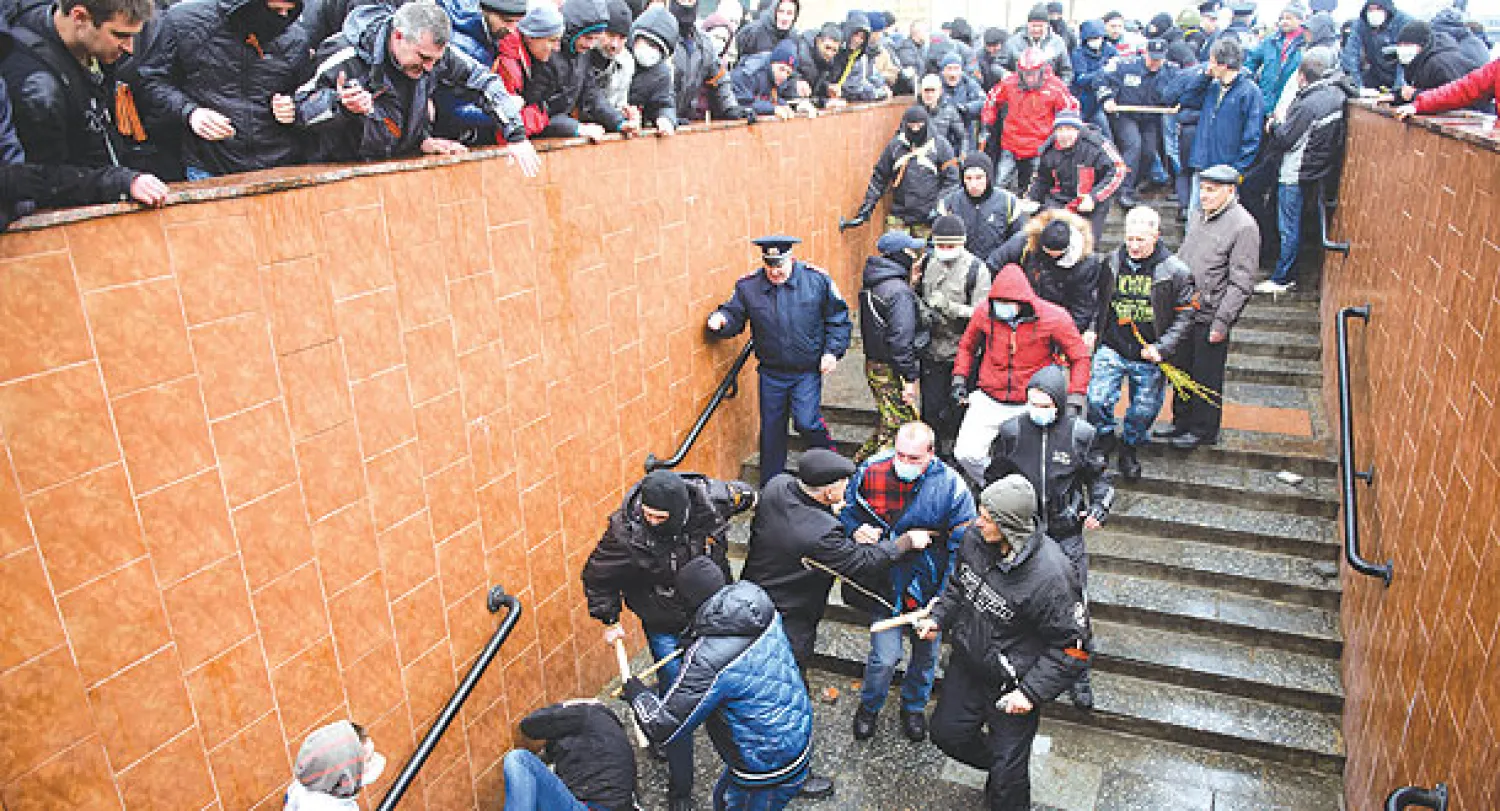 متظاهرون موالون لروسيا ينهالون على ناشط مؤيد للغرب ضربا في مدينة خاركيف الشرقية أمس (أ.ب)