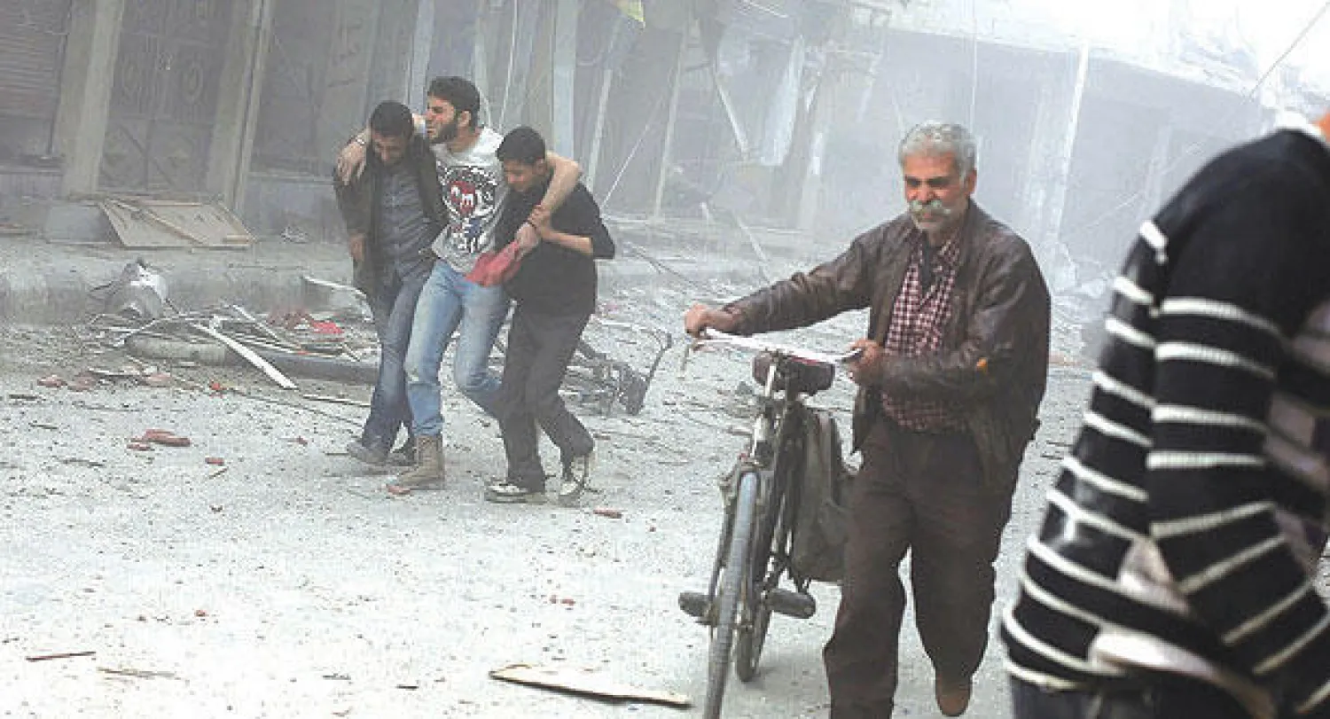 مواطنون في مدينة دوما يحاولون الهرب من الأتربة الناجمة عن قصف جوي للنظام السوري أمس (أ.ف.ب)