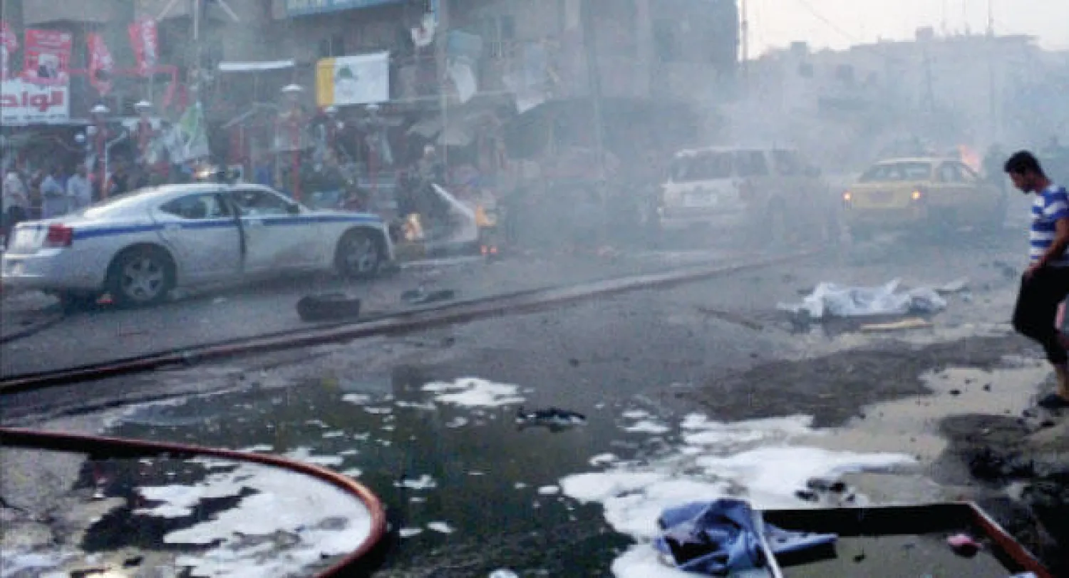 عراقيون يعاينون موقع انفجار سيارة مفخخة في منطقة الكرادة التجارية ببغداد أمس (أ.ب)