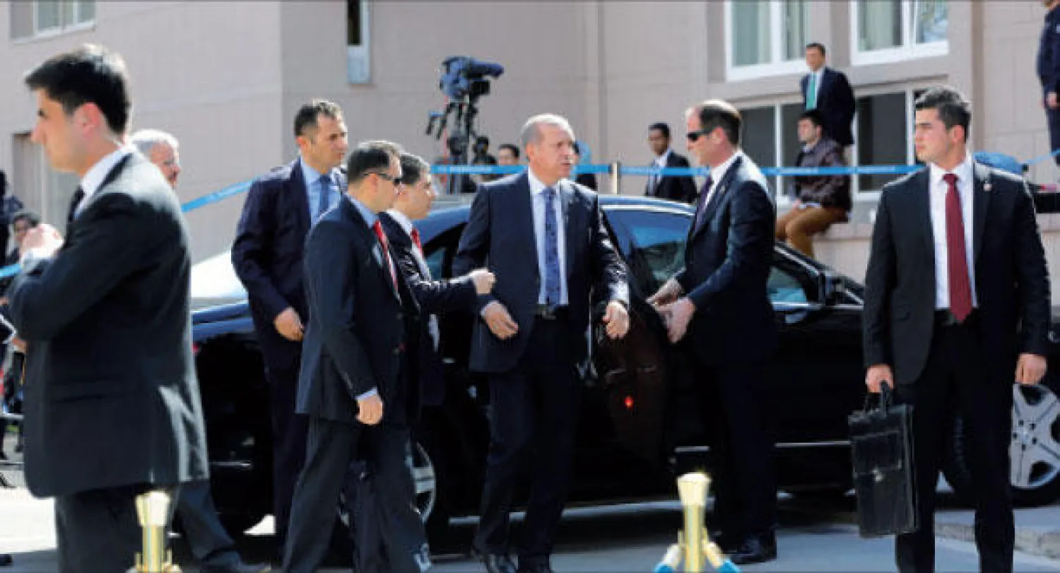 رئيس الحكومة التركية رجب طيب إردوغان محاطا بحراسه الشخصيين خارج مكتبه في أنقرة أمس (أ.ب)
