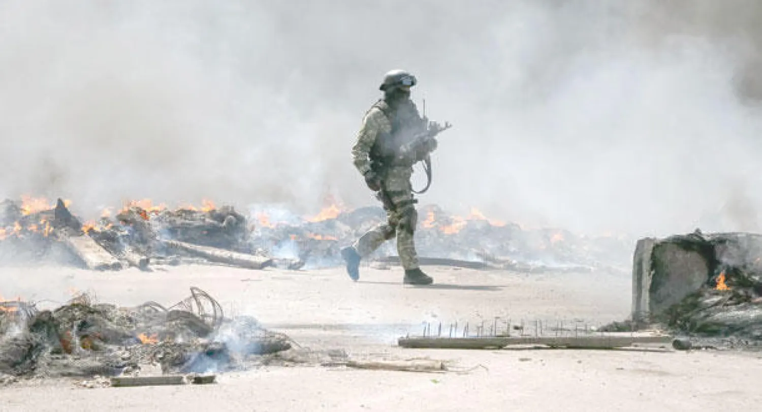 جندي أوكراني أمام نقطة تفتيش أضرم فيها ناشطون موالون لموسكو النار قرب مدينة سلافيانسك التي باتت معقلا للانفصاليين بشرق البلاد أمس (رويترز)