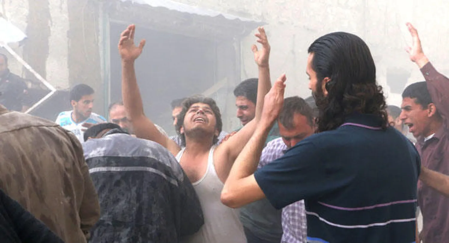 سوريون مذهولون بعد غارة جوية  لاحدى طائرات النظام السوري على سوق في قرية الأتارب بمحافظة حلب في الشمال امس، قتلت ما لا يقل عن 27 شخصا، بينهم ثلاثة أطفال، حسب المرصد السوري لحقوق الإنسان