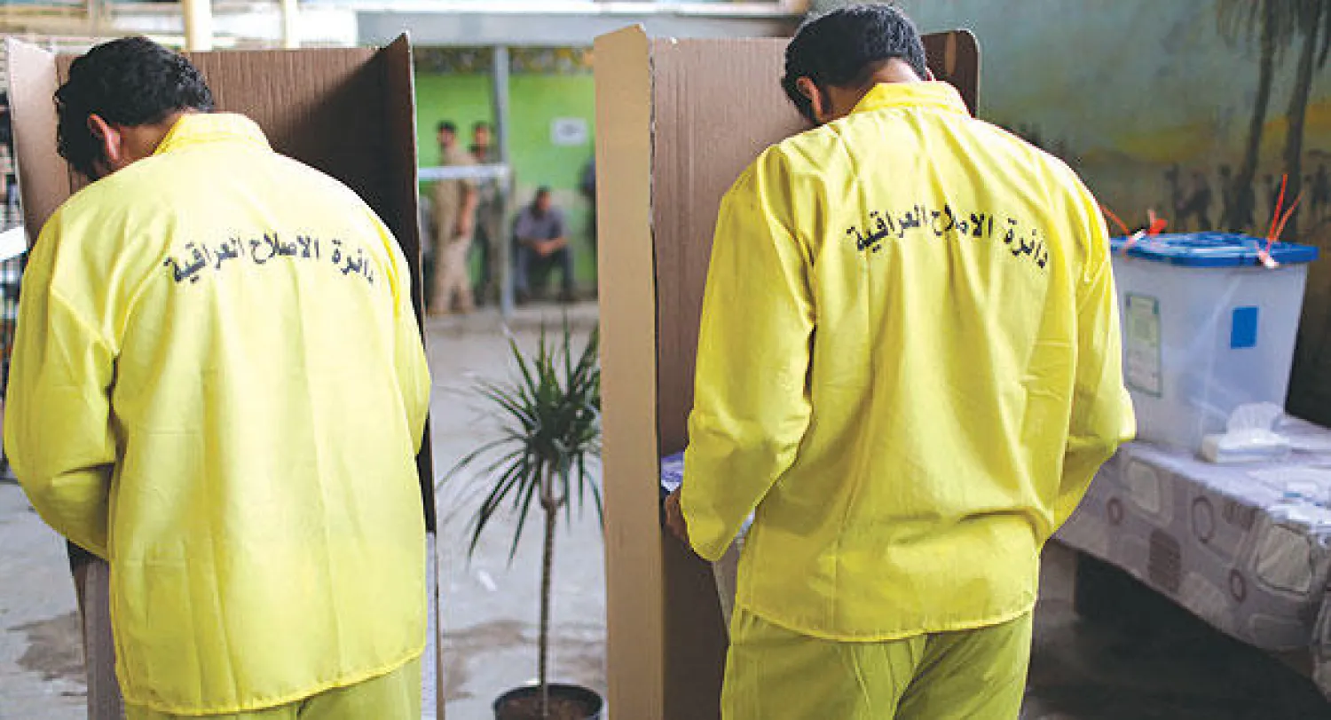 سجينان يدليان بصوتيهما في سجن الرصافة ببغداد أمس (رويترز)