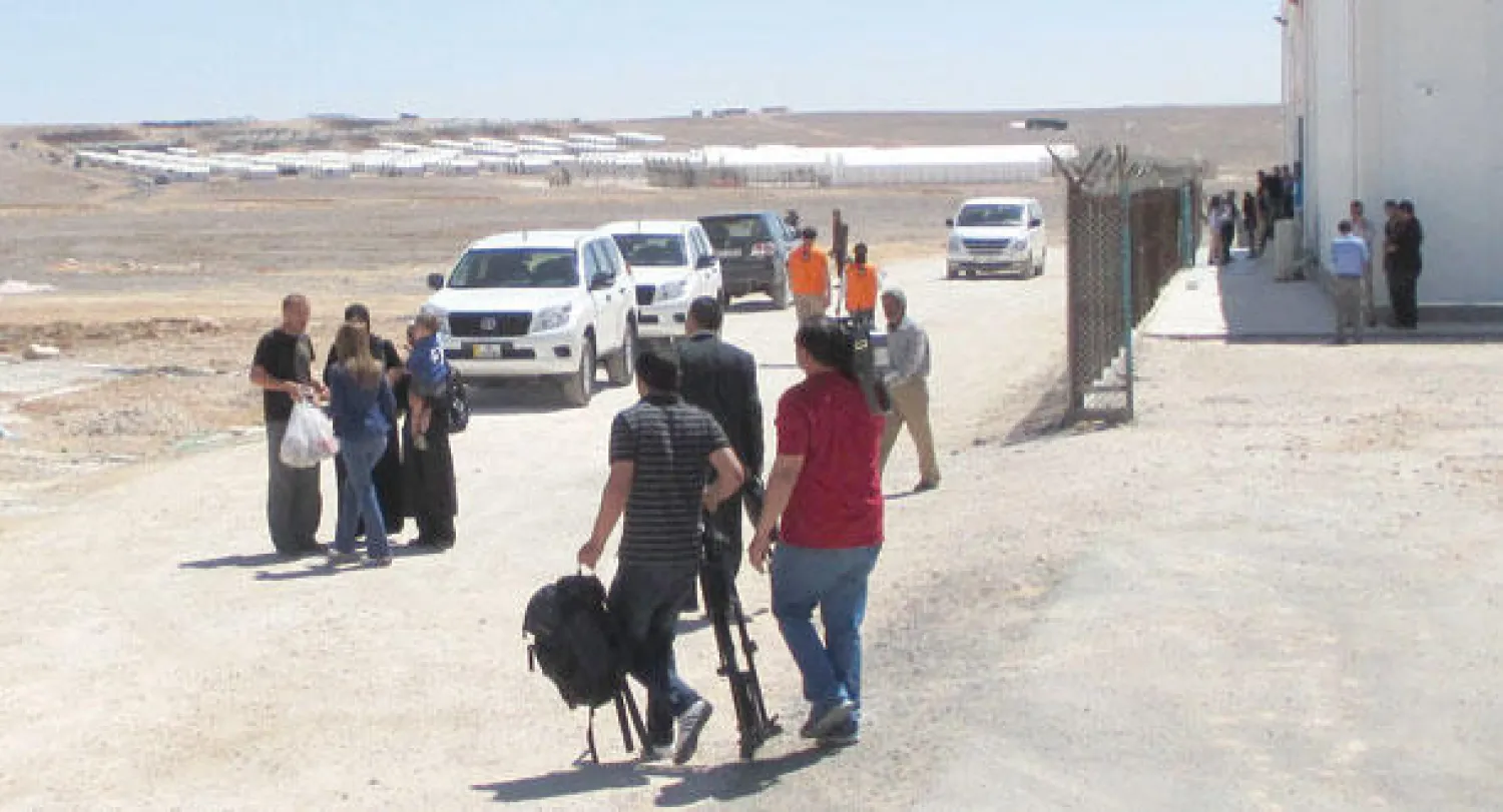 بعض اللاجئين في محيط مركز التسوق بمخيم الأزرق الأردني الجديد («الشرق الأوسط»)