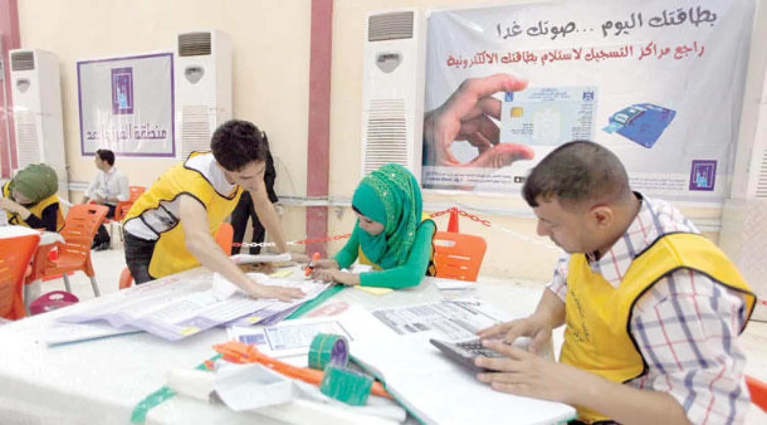 عمال تابعون للجنة الانتخابات يعدون الأصوات في مركز ببغداد أمس (رويترز)