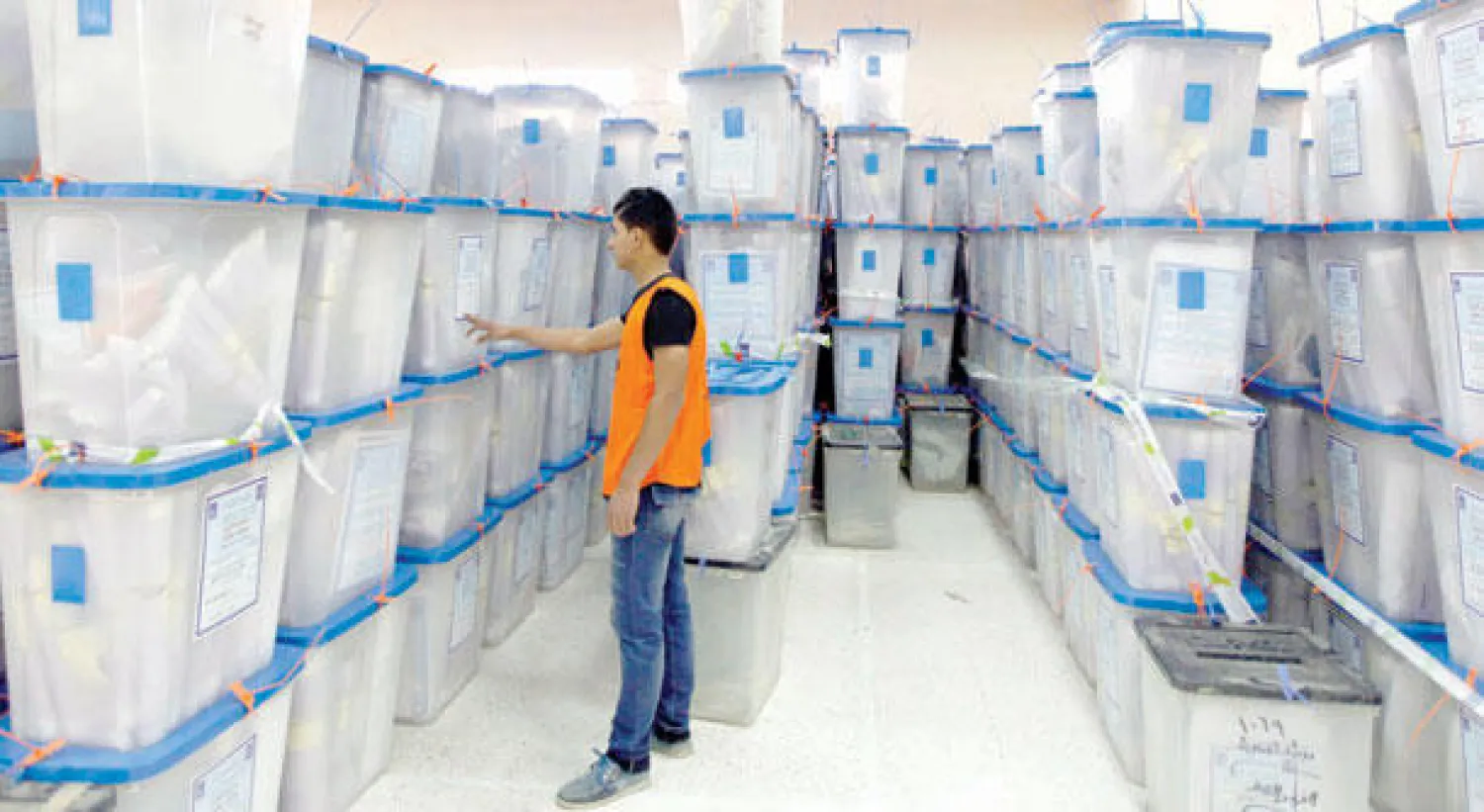 موظف لدى المفوضية العليا للانتخابات يفحص الأرقام على صناديق الاقتراع في مركز انتخابي ببغداد أمس (رويترز)