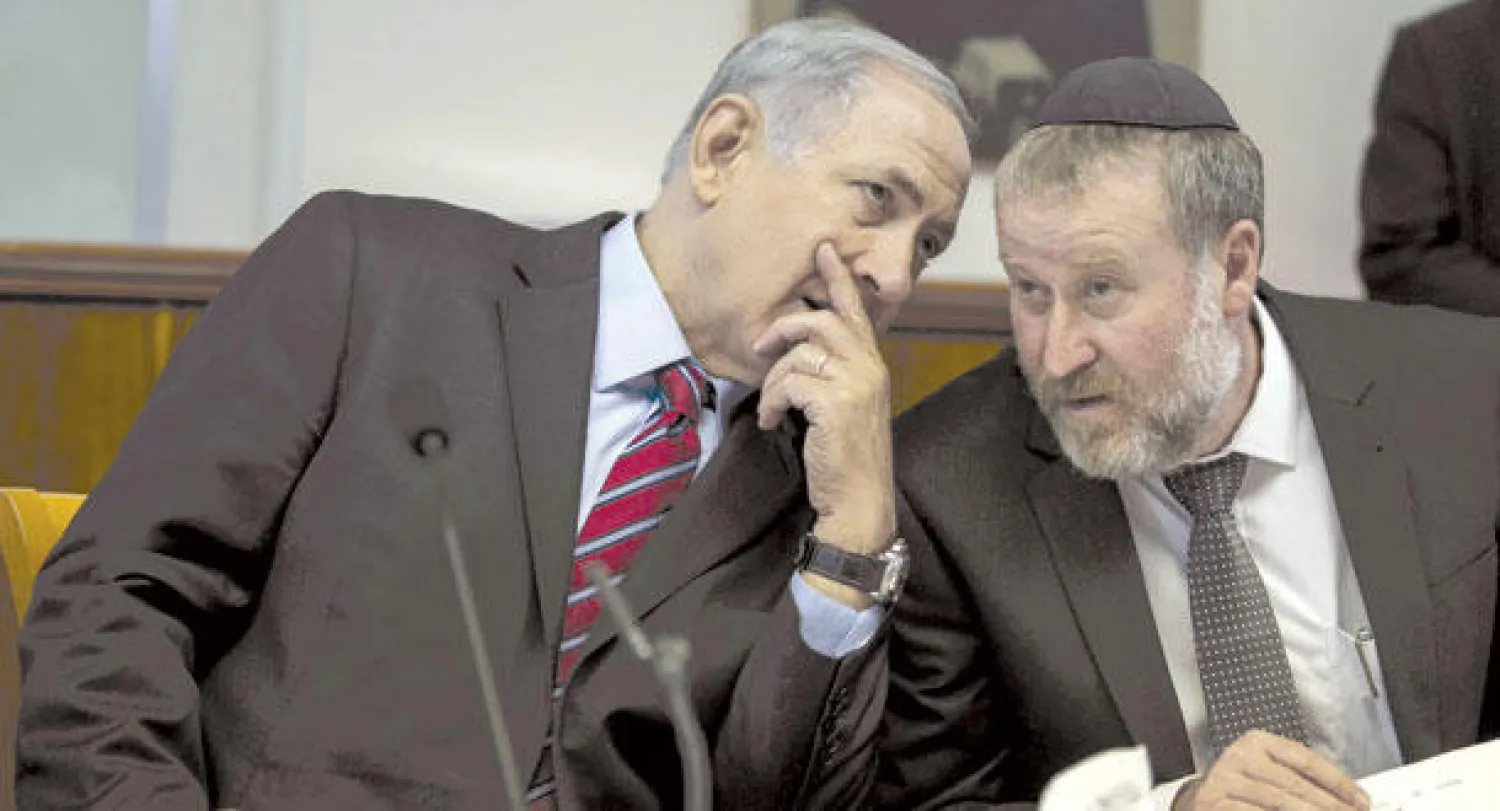 رئيس الوزراء الإسرائيلي بنيامين نتنياهو يتحدث إلى أمين عام مجلس الوزراء أفيخاي مندلبليت خلال اجتماع الحكومة الذي عقد في القدس أمس (أ.ف.ب)