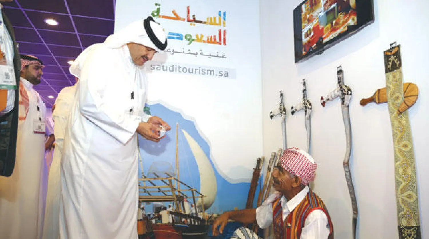 الأمير سلطان بن سلمان يطلع على عمل أحد الحرفيين المشاركين ضمن جناح السعودية في ملتقى السفر العربي («الشرق الأوسط»)
