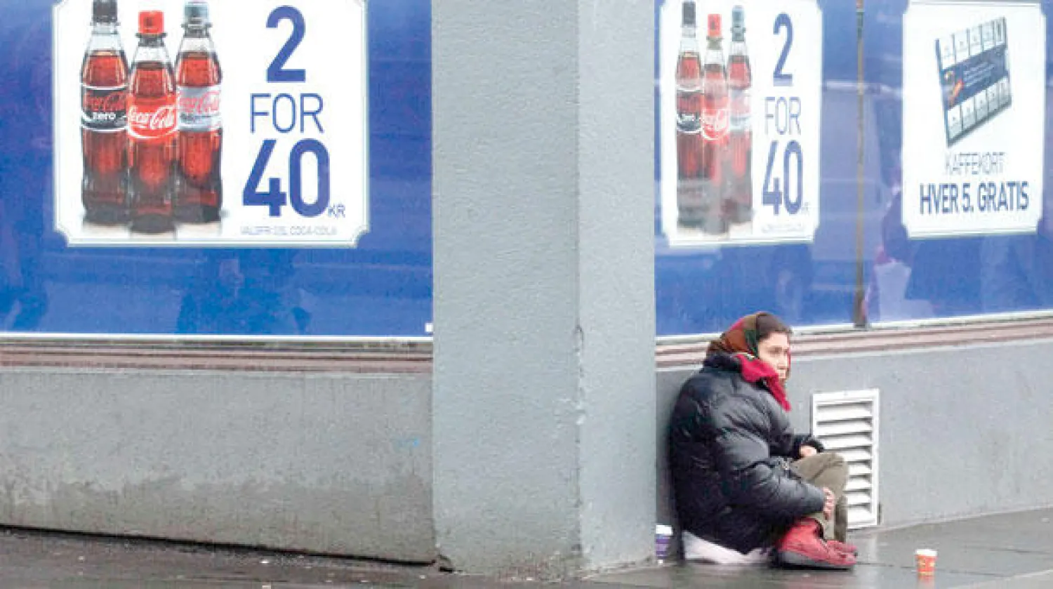 صورة لوكالة «رويترز» يبدو غريبا التقاطها في النرويج لامرأة تشحذ في الطريق أمام متجر بمدينة بيرغين بجنوب غرب البلاد (رويترز)