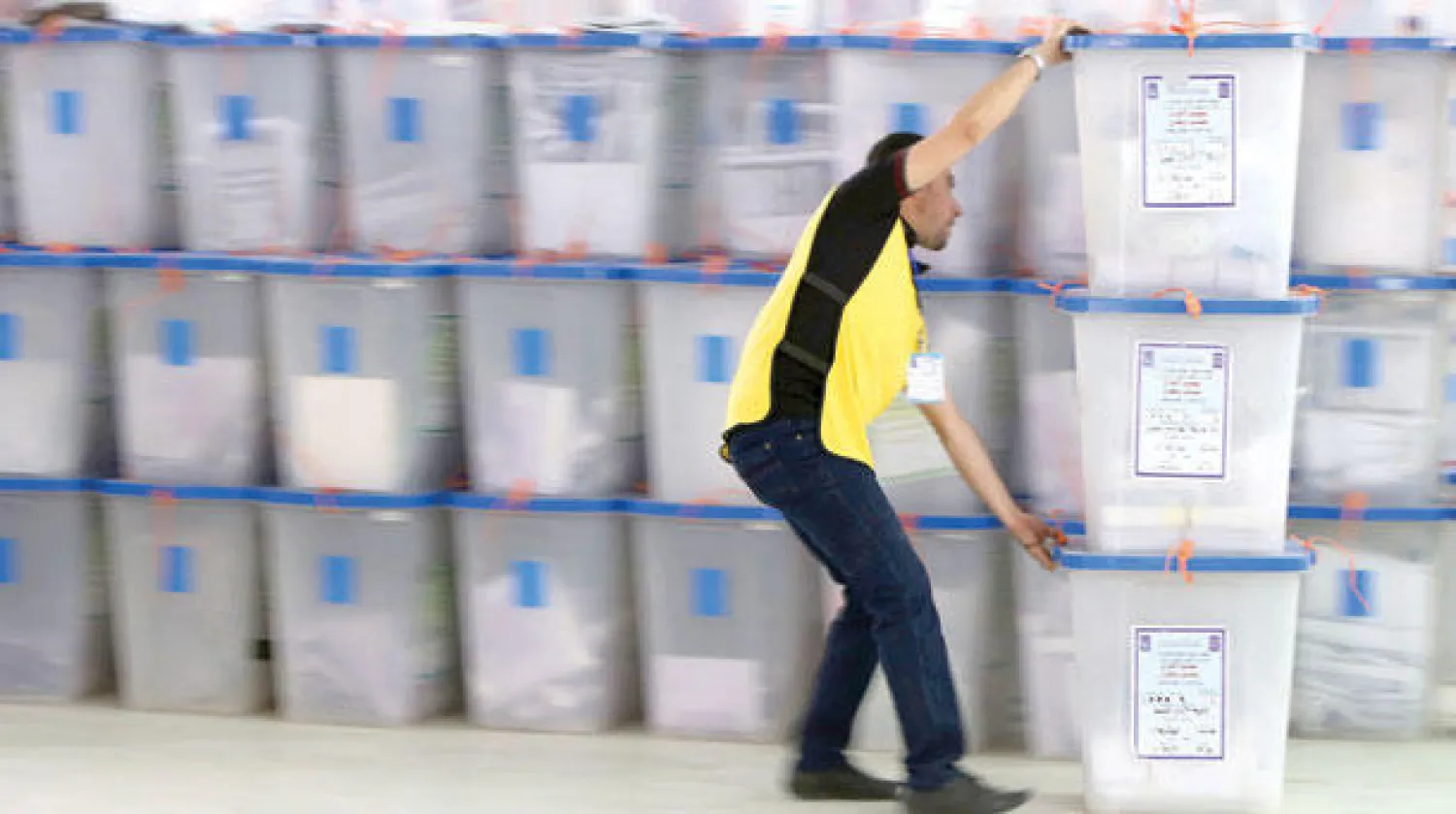 موظف في اللجنة الانتخابية يتابع ترتيب صناديق الاقتراع في المركز الرئيسي لفرز الأصوات في العاصمة بغداد (أ.ف.ب)