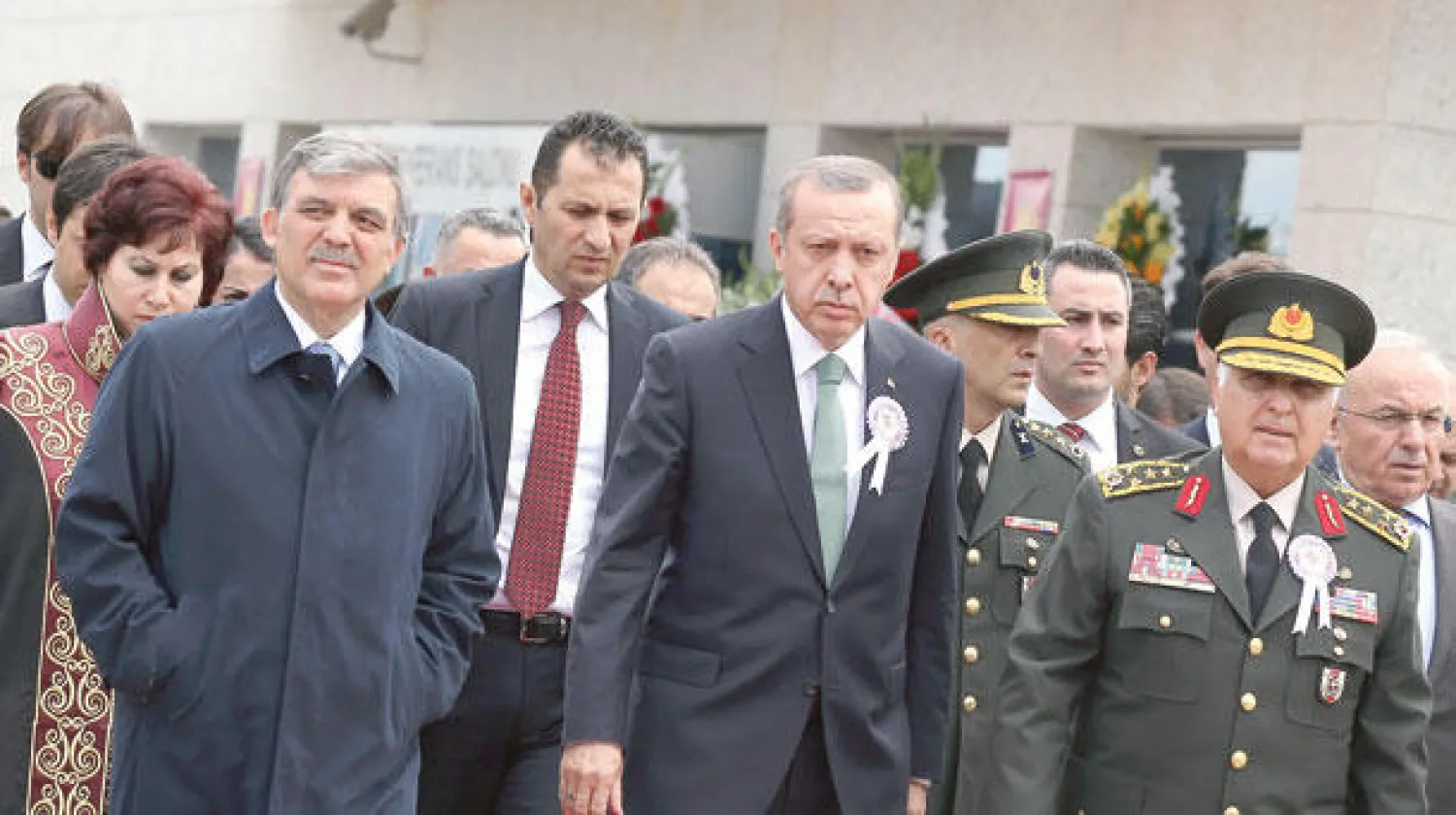 إردوغان (وسط) والرئيس عبد الله غل (يسار) ورئيس الأركان نجدت أوزيل (يمين) أثناء مغادرتهم الاجتماع الذي شهد مشادة بين رئيس الوزراء ونقيب المحامين في أنقرة أمس (أ.ب)