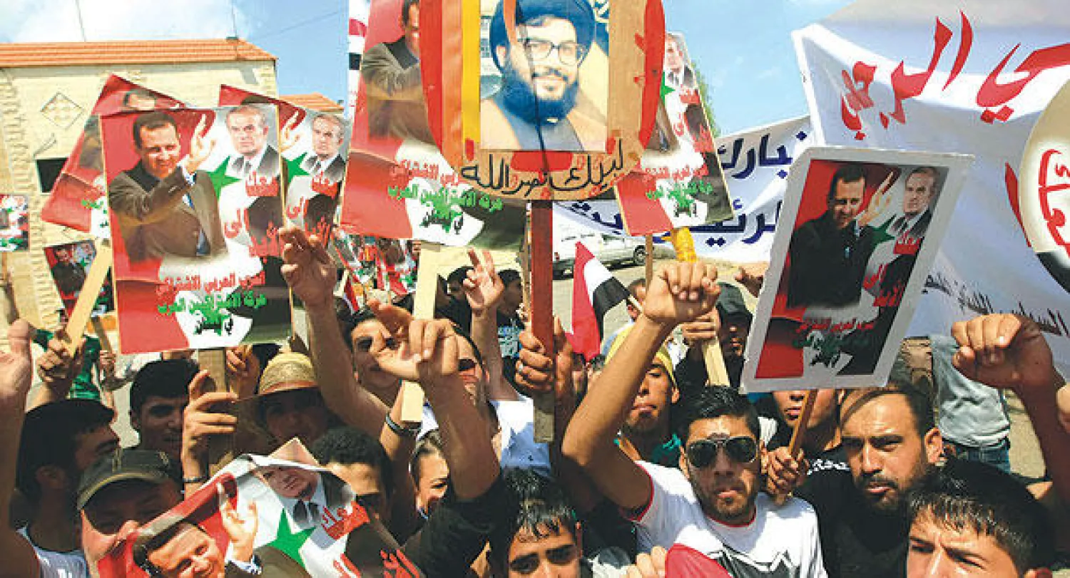 لبنانيون في مسيرة تأييد للرئيس السوري بشار الأسد وزعيم حزب الله حسن نصر الله  بمدينة صيدا أول من أمس (أ.ب)
