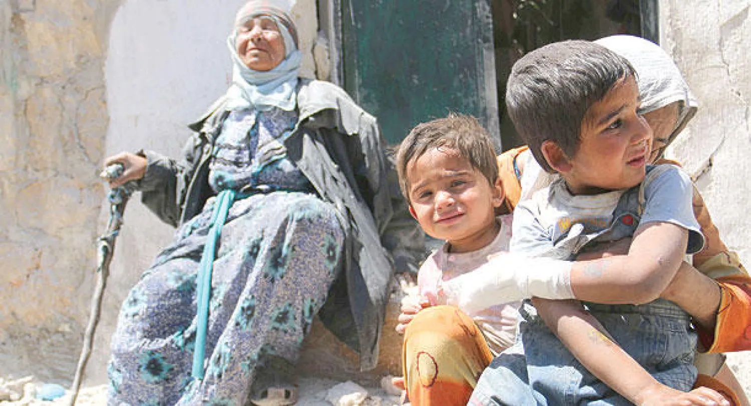 سورية تحتضن طفليها وأخرى في صدمة بعد قصف حكومي استهدف مدينة حلب أمس (أ.ف.ب)