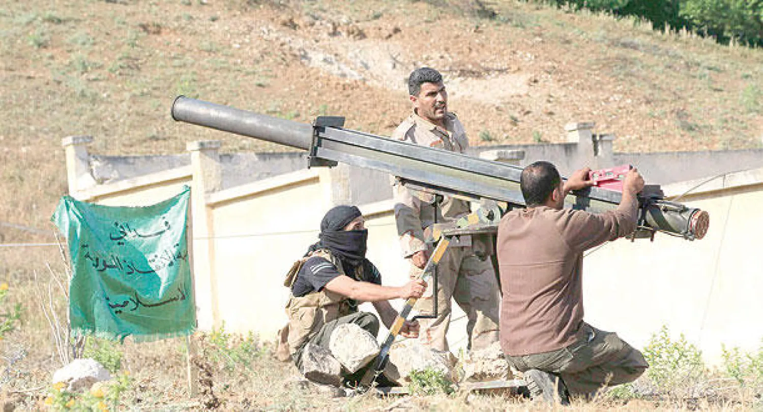 مقاتلون من الجيش السوري الحر يعدون لإطلاق قذيفة تستهدف القوات النظامية في حماه أمس (رويترز)