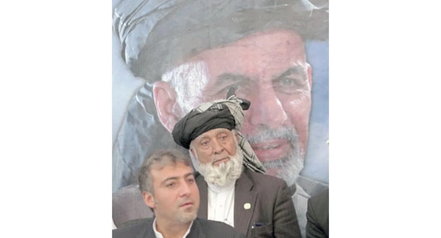 مناصران للمرشح الرئاسي أشرف غني يستمعان إلى مؤتمر صحافي له في كابل أمس (أ.ب)