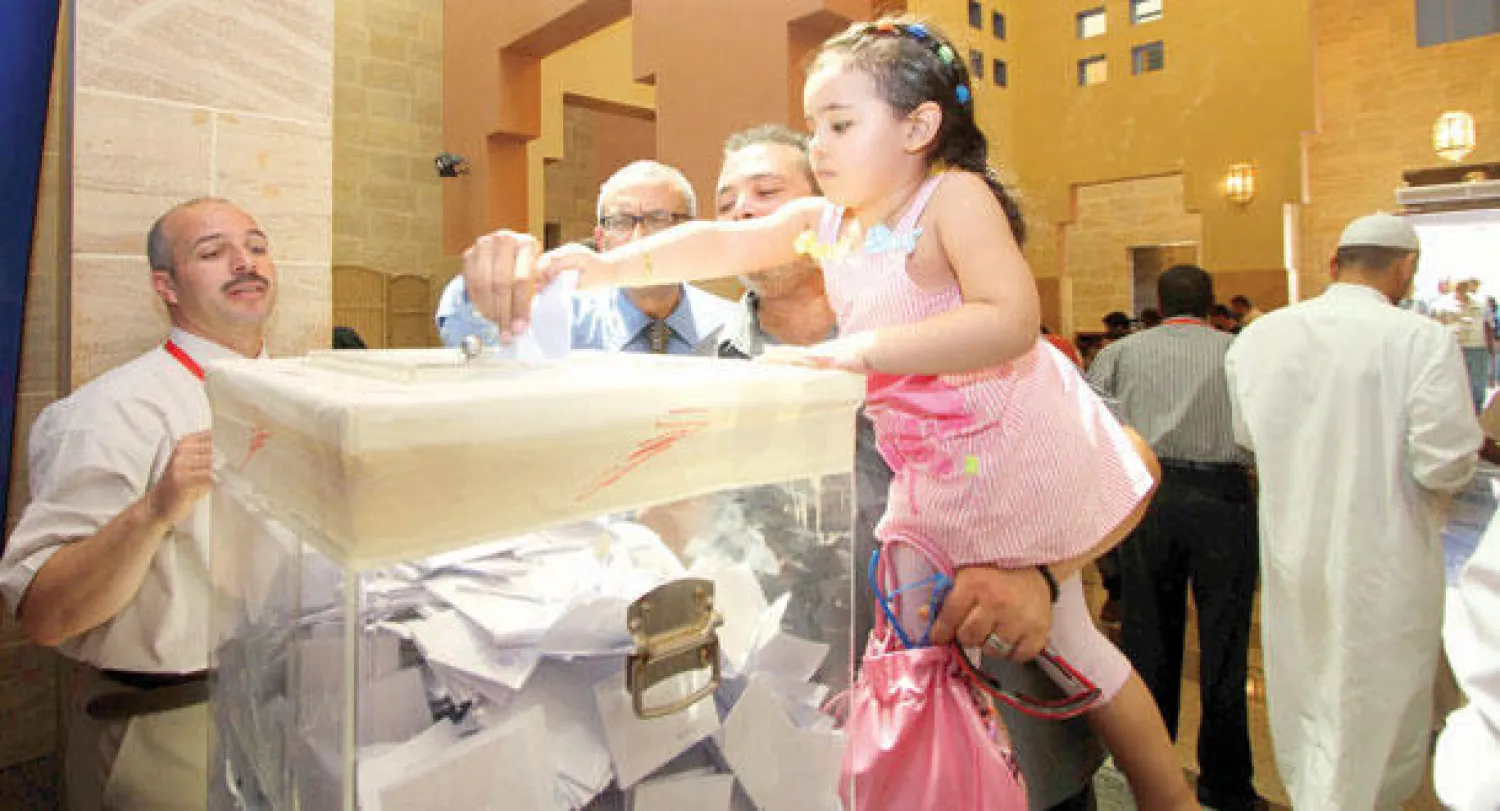 طفلة مصرية تساعد والدها خلال الإدلاء بصوته في القنصلية المصرية بجدة أمس (تصوير: أحمد حشاد)