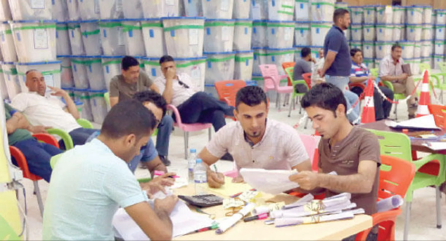 جانب من عمليات الفرز والعد لأصوات الناخبين العراقيين التي تجري بطريقة يدوية في معرض بغداد الدولي أمس (أ.ب)