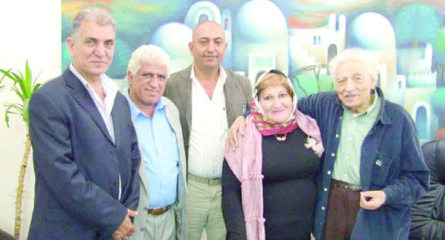 الراوي (يمين) مع مجموعة من الفنانين العراقيين أمام أحد أعماله