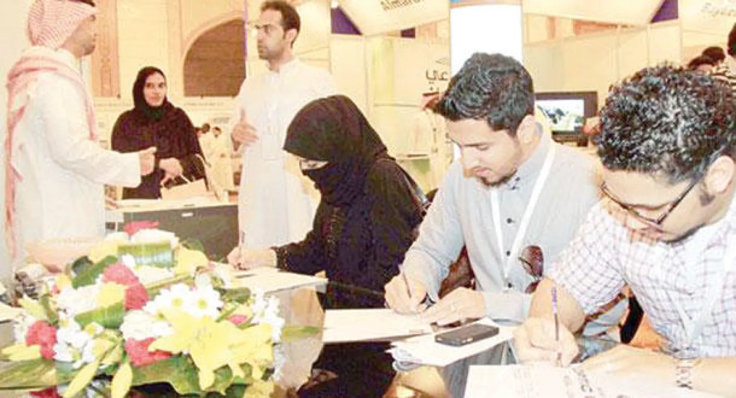 شبان وفتيات يسجلون بياناتهم في معرض للتوظيف بجدة مطلع الأسبوع الحالي («الشرق الأوسط»)