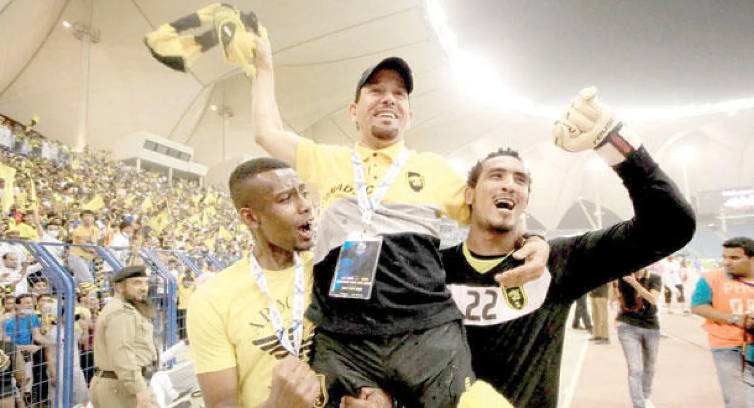 القروني محتفلا مع لاعبيه  فواز القرني وحمد المنتشري  (تصوير: علي العريفي)