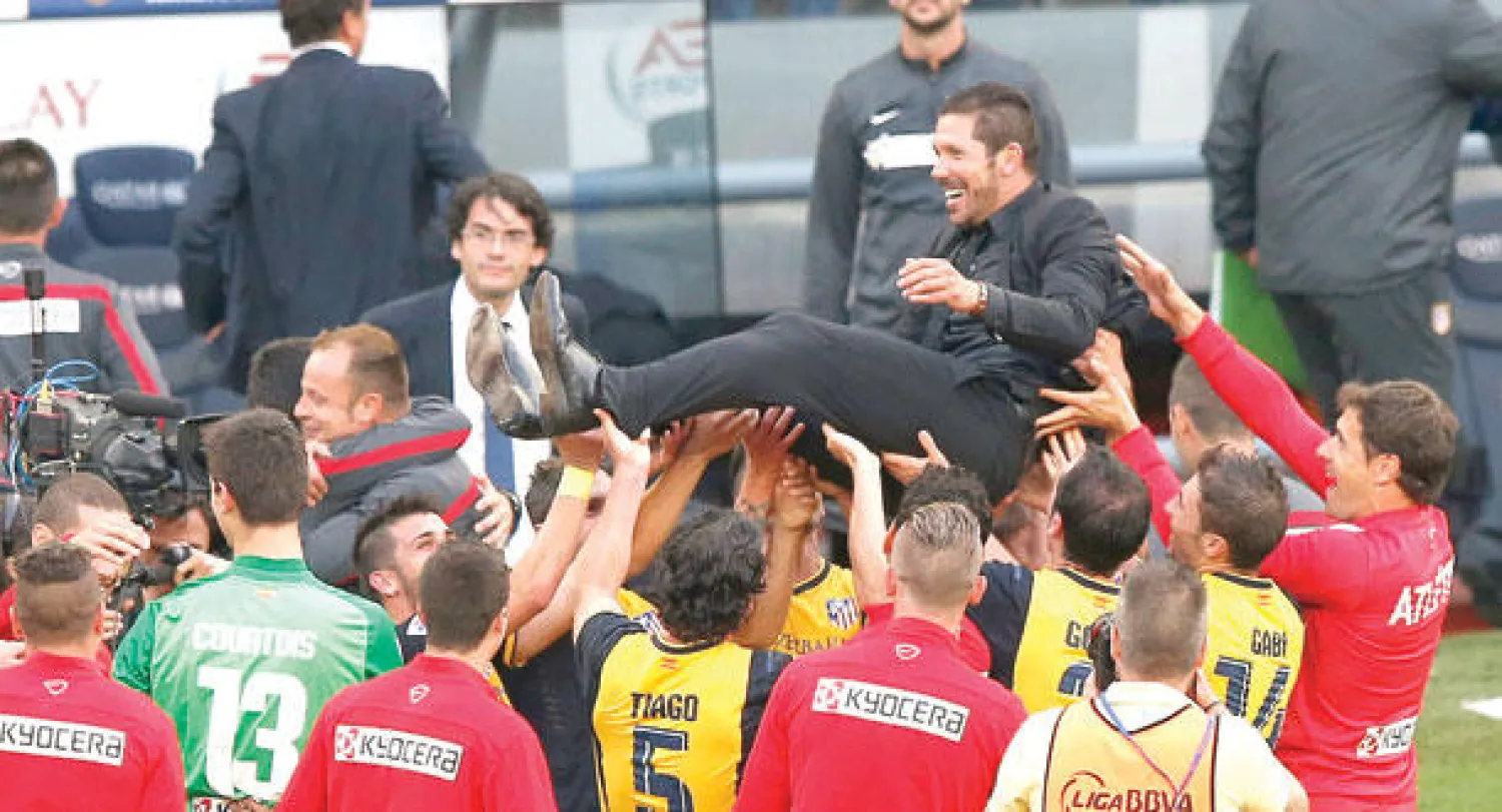 أتليتكو بطلا للدوري الإسباني للمرة العاشرة في تاريخه.. ولاعبوه يحتفلون بمدربهم سيميوني (رويترز)