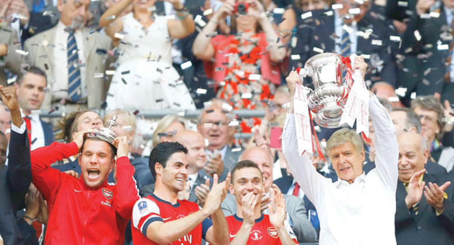 آرسنال ومدربه فينغر على منصة التتويج بعد تسع سنوات (أ.ب)