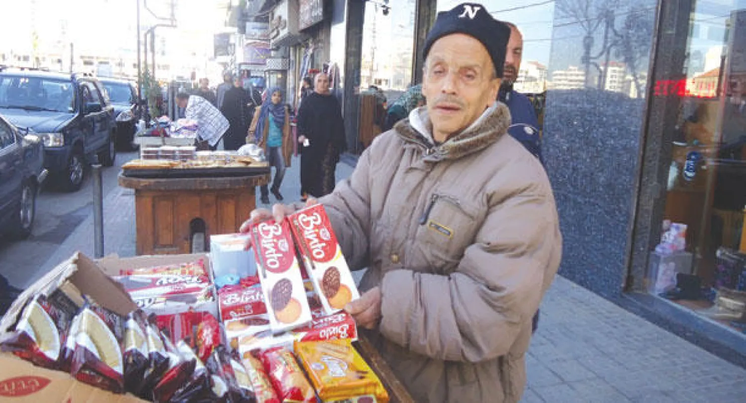 أبو مروان يقف بجانب عربته ينادي على بضاعته من السكاكر والحلوى («الشرق الأوسط»)