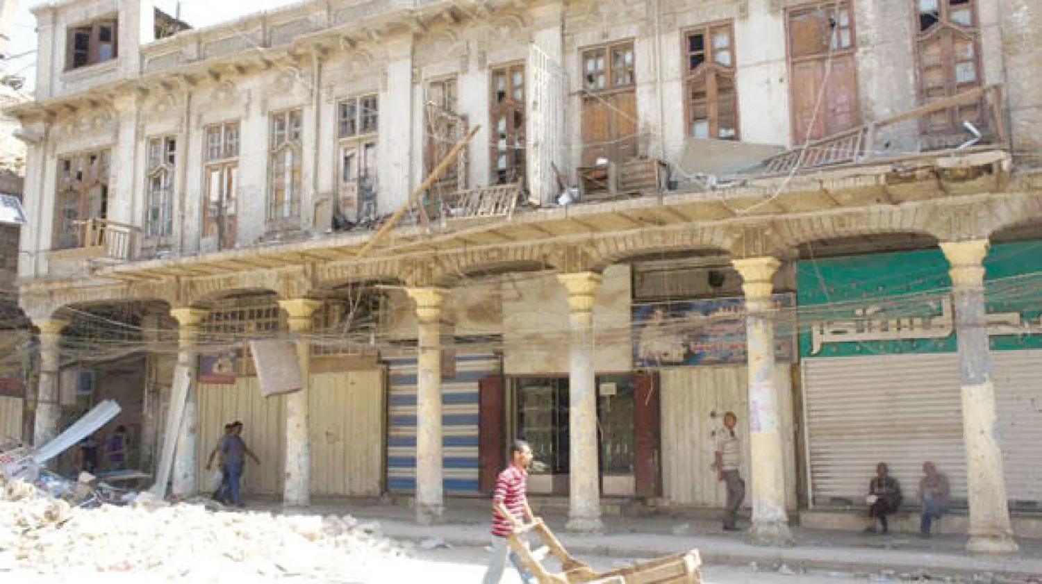 شاب عراقي يدفع عربته وسط خراب شارع الرشيد أول شوارع بغداد («الشرق الأوسط»)