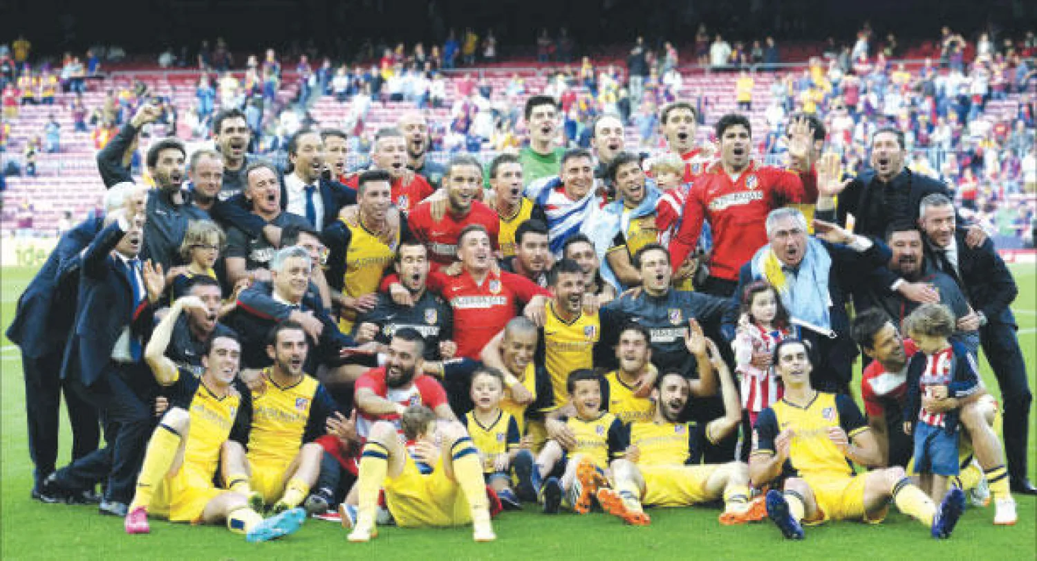 لاعبو أتليتكو يحتفلون بالفوز بالدوري الإسباني في معقل المنافس وحامل اللقب برشلونة (أ.ف.ب)