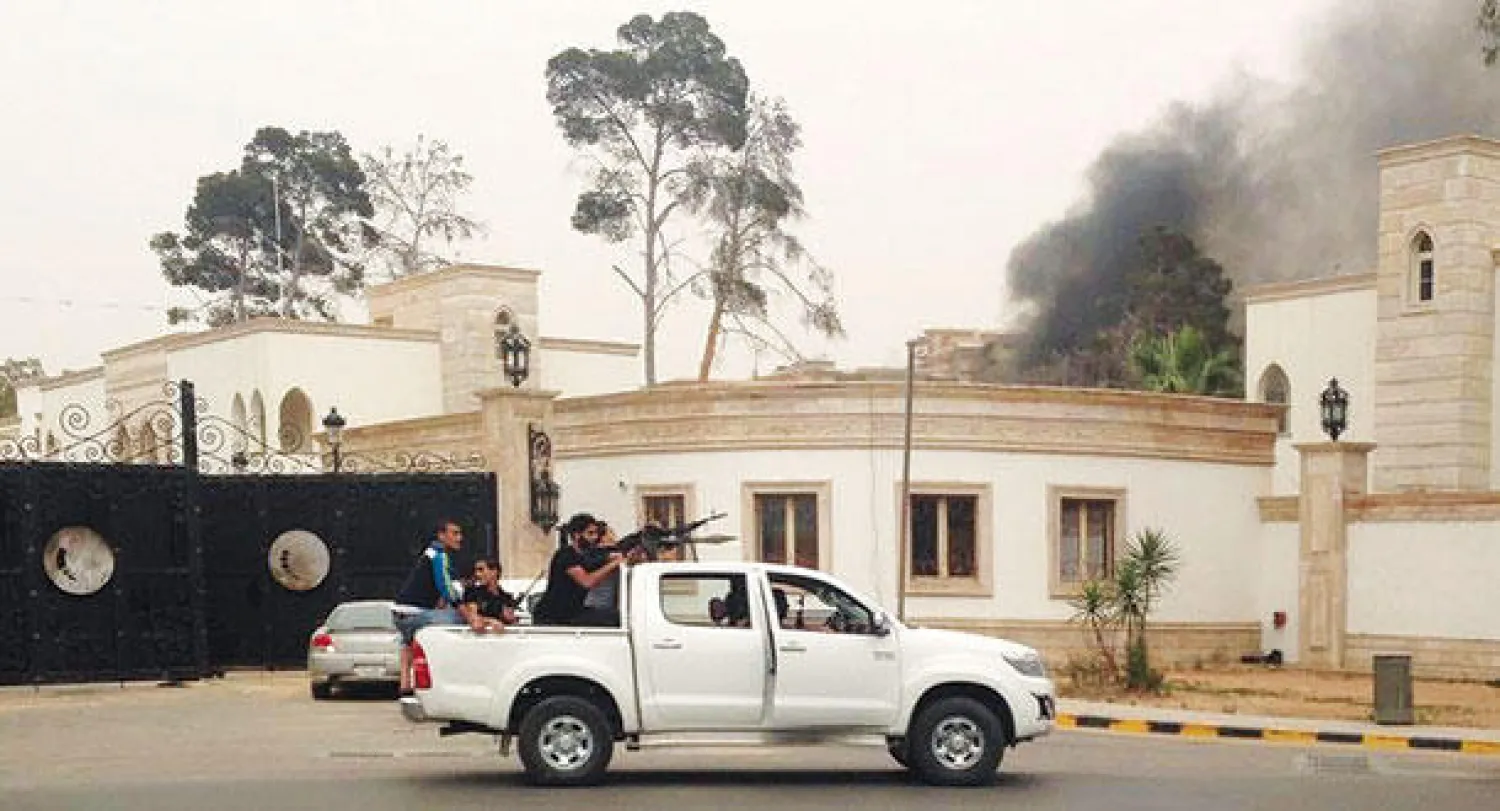 الدخان يتصاعد خلف مبنى البرلمان الليبي الذي جرى اقتحامه من قبل مسلحين أمس (رويترز)