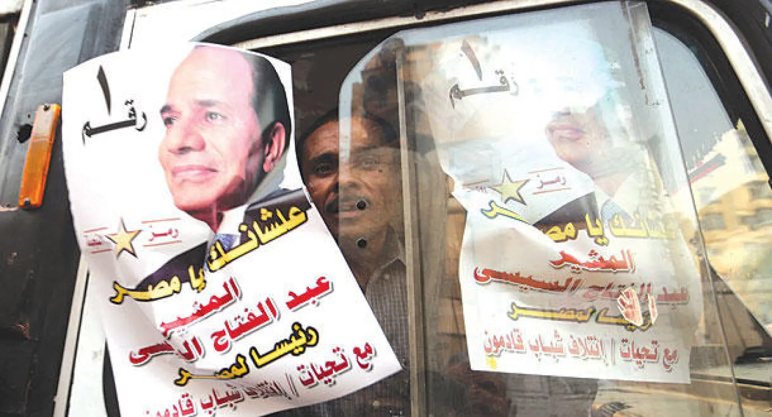 مواطن مصري يرفع  صورة المشير عبد الفتاح السيسي المرشح الرئاسي المصري بوسط القاهرة أمس (إ.ب.أ)