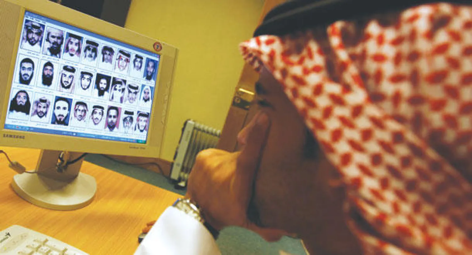 سعودي يتصفح قائمة مطلوبين أمنيين نشرتها وزارة الداخلية سابقا («الشرق الأوسط»)