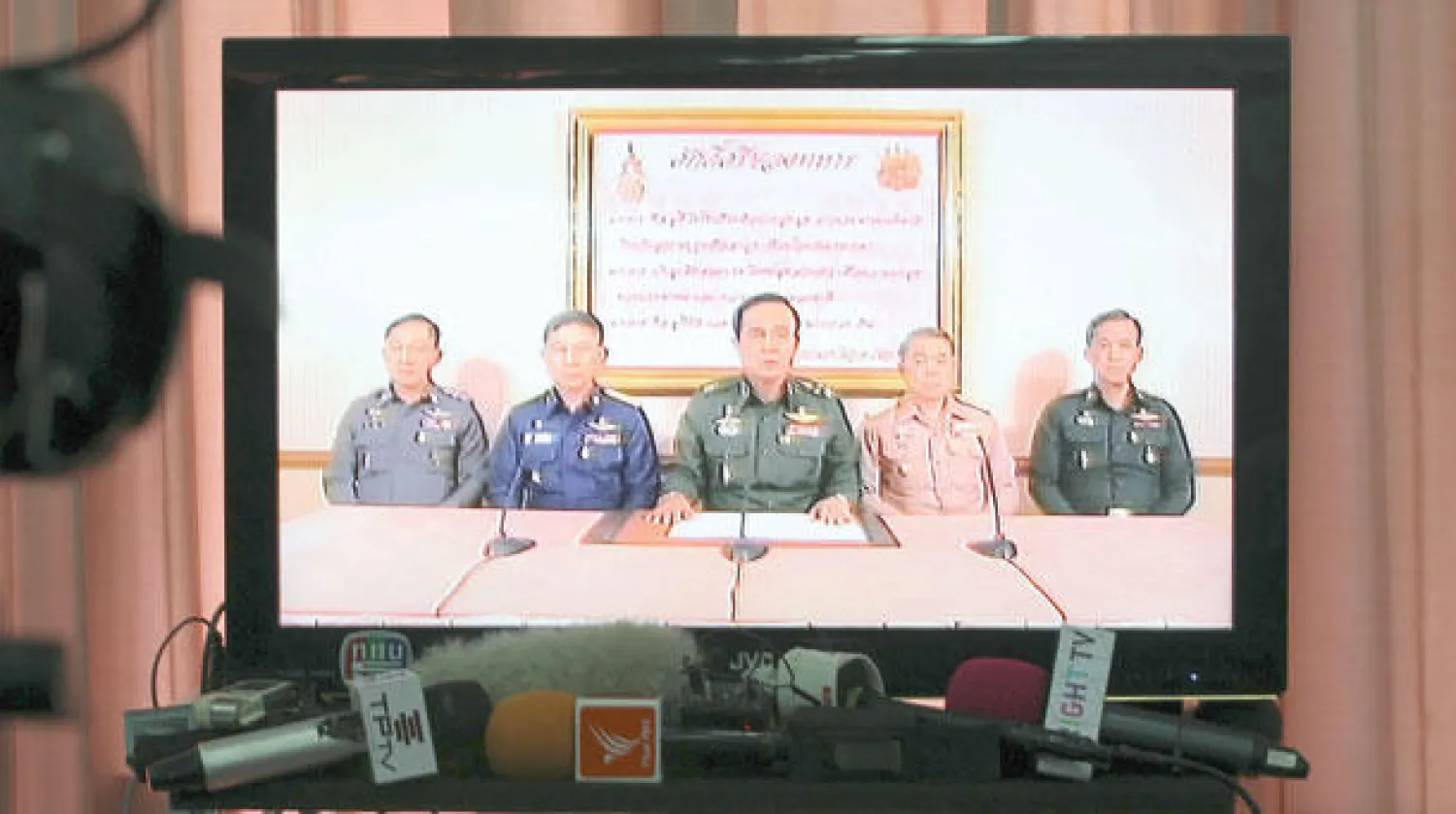 قائد سلاح البر الجنرال برايوت (وسط) أثناء إعلانه الانقلاب عبر التلفزيون وبدا جالسا إلى جانبه ضباط آخرون في بانكوك أمس (أ.ب)