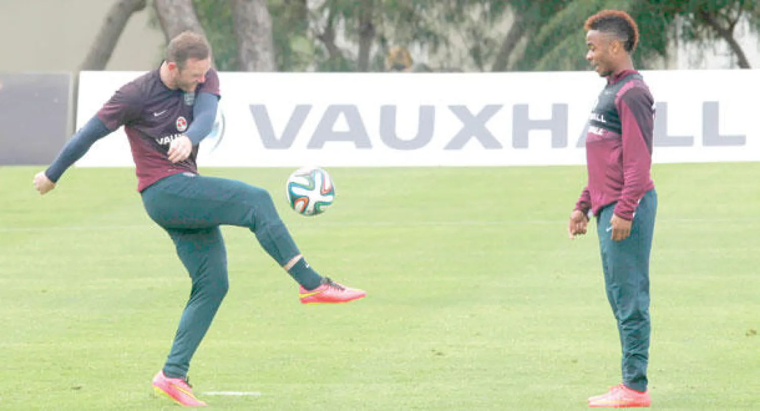 روني (يسار) يتبادل الكرة مع ستيرلينغ في تدريبات منتخب إنجلترا (أ.ب)