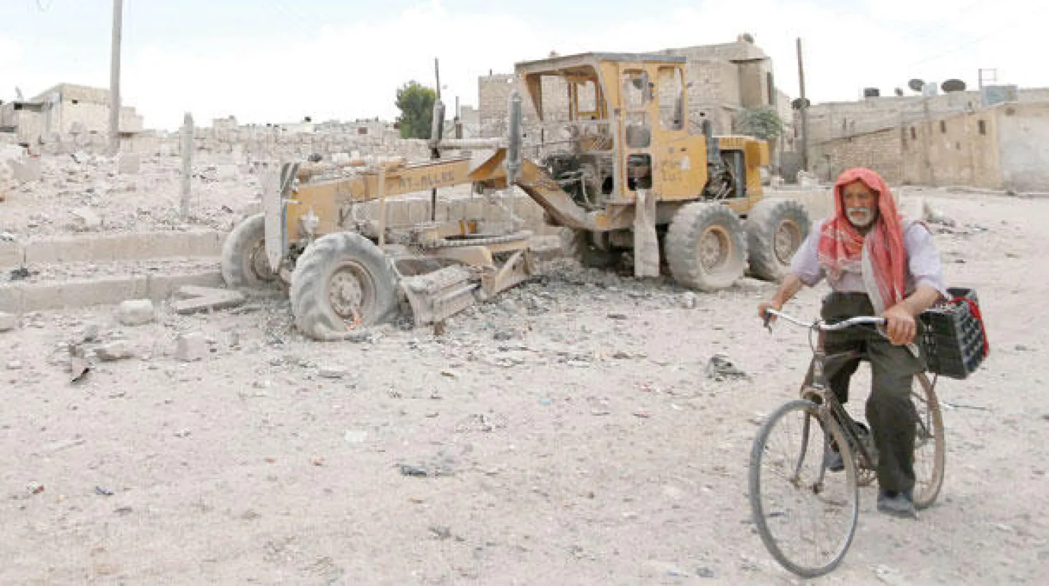 سوري يتجول على دراجته الهوائية في شارع تعرضت لقصف بالبراميل من قوات النظام السوري أمس (رويترز)