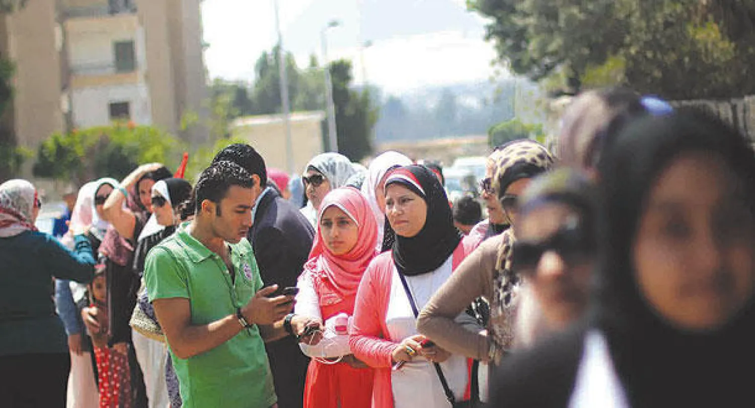 مجموعة من النساء والفتيات في طابور بإحدى اللجان بمحافظة الجيزة أمس (أ.ب)