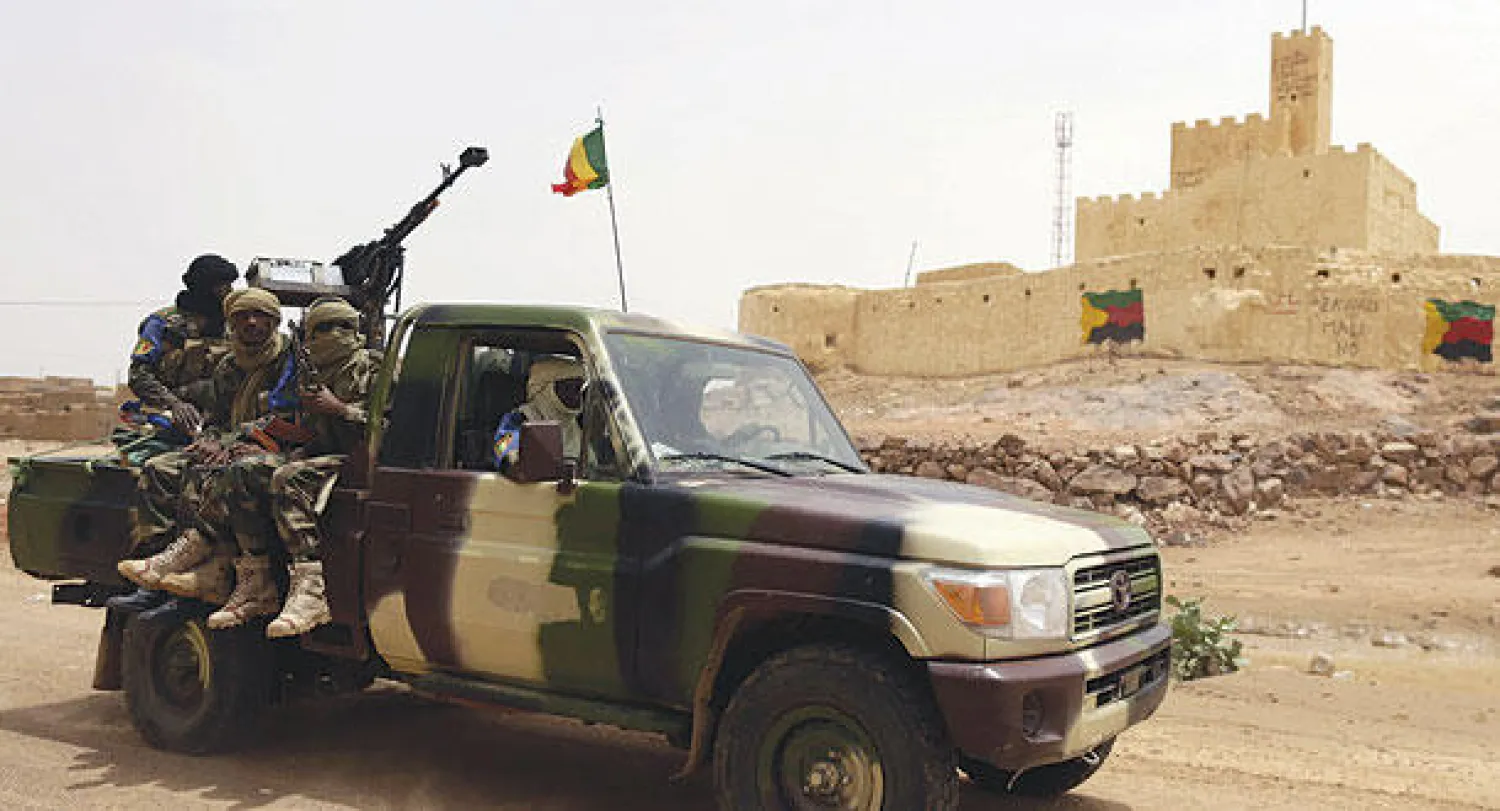 جنود ماليون يقومون بحراسة مدخل مدينة كيدال بعد الأحداث الدامية  الأخيرة التي شهدتها المدينة (أ.ف.ب)