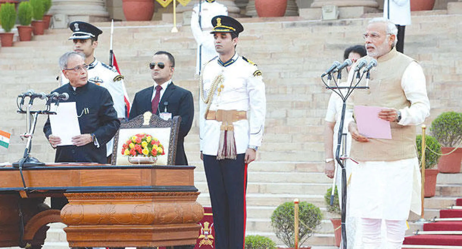 مودي (يمين) يؤدي اليمين الدستورية بحضور رئيس البلاد موخيرجي (يسار) في نيودلهي أمس (رويترز)