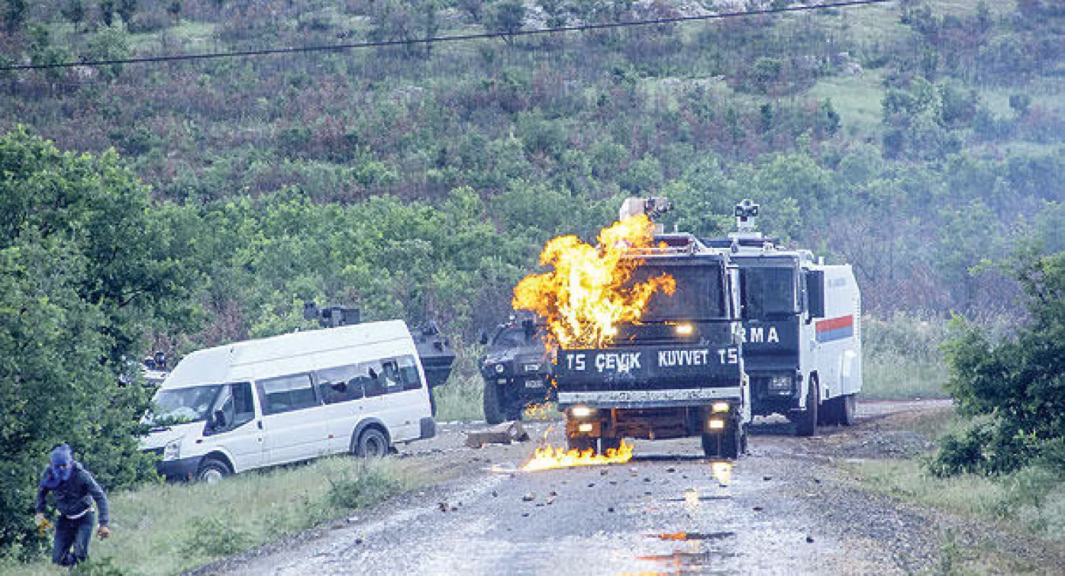 مسلح كردي يلقي زجاجة حارقة على سيارة شرطة مكافحة الشغب في ديار بكر التركية (أ.ف.ب)