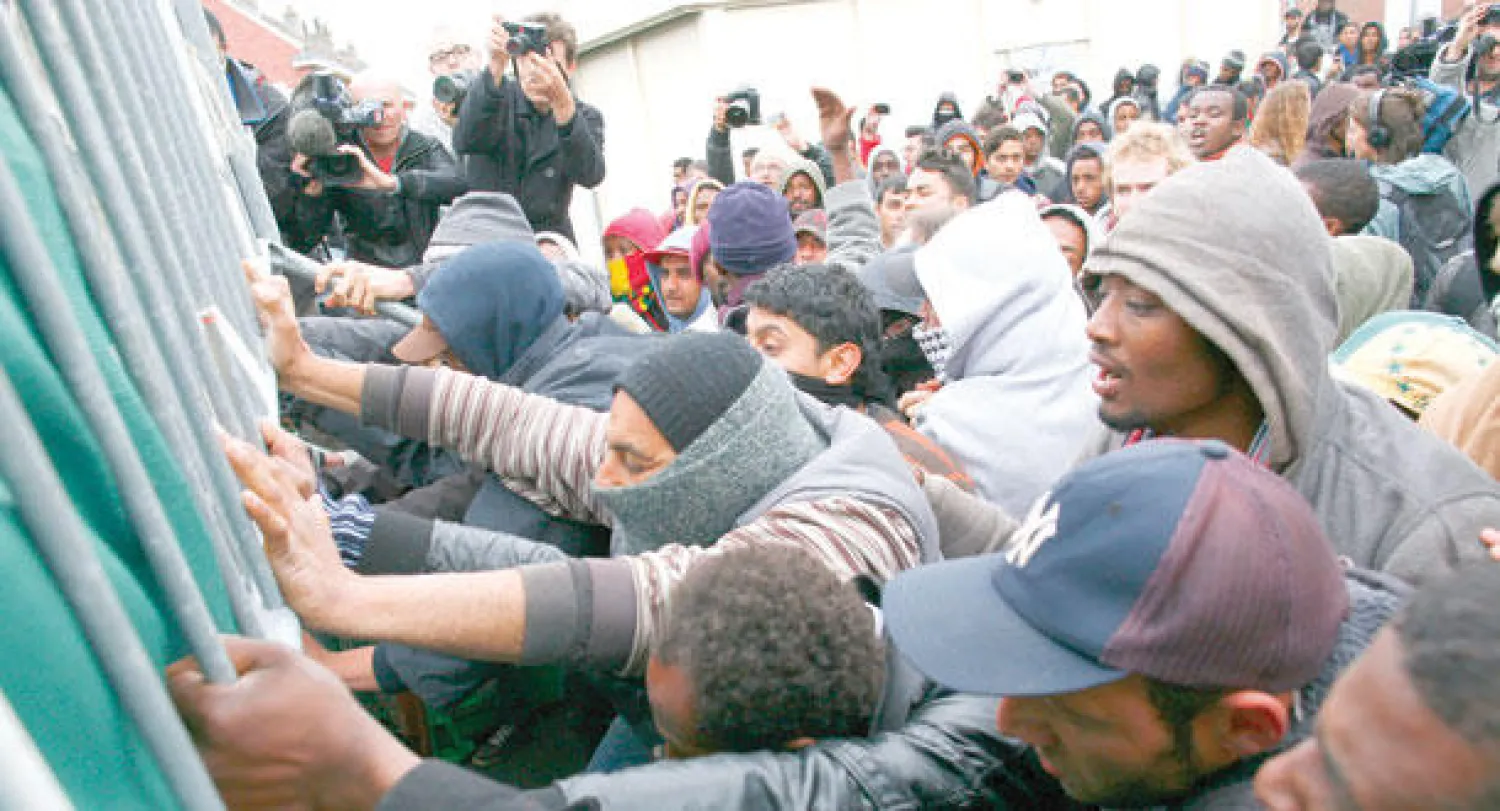 مهاجرون حاولوا منع قوات الشرطة من تفكيك مخيماتهم في كاليه بشمال فرنسا أمس (أ.ب)