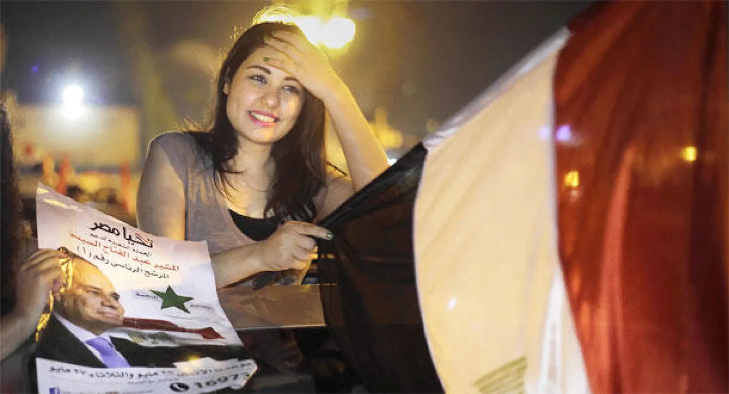 مؤيدة للسيسي تحمل علم مصر أثناء الاحتفال بفوزه بالرئاسة في ميدان التحرير وسط القاهرة ليلة أول من أمس  (أ.ب)