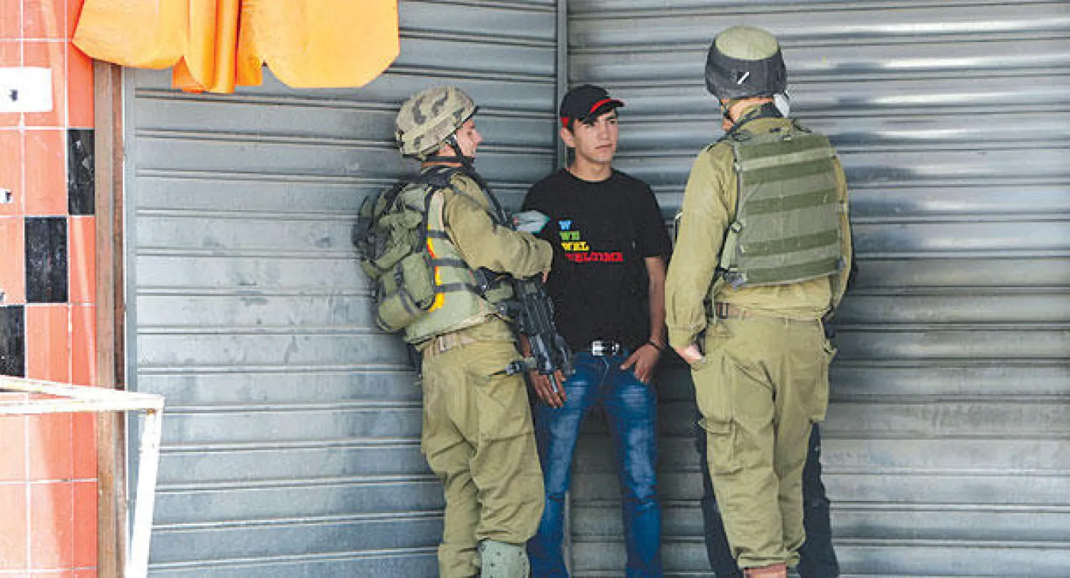 جنديان يستجوبان فلسطينيا في نابلس أمس (أ.ب)