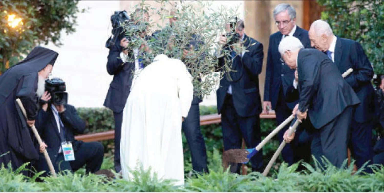 من اليسار: البطريرك المسكوني بارثولوميو والبابا فرنسيس والرئيس الفلسطيني محمود عباس والرئيس الإسرائيلي شيمعون بيريس يشتركون في غرس شجرة زيتون في حديقة الفاتيكان أمس (إ.ب.أ)
