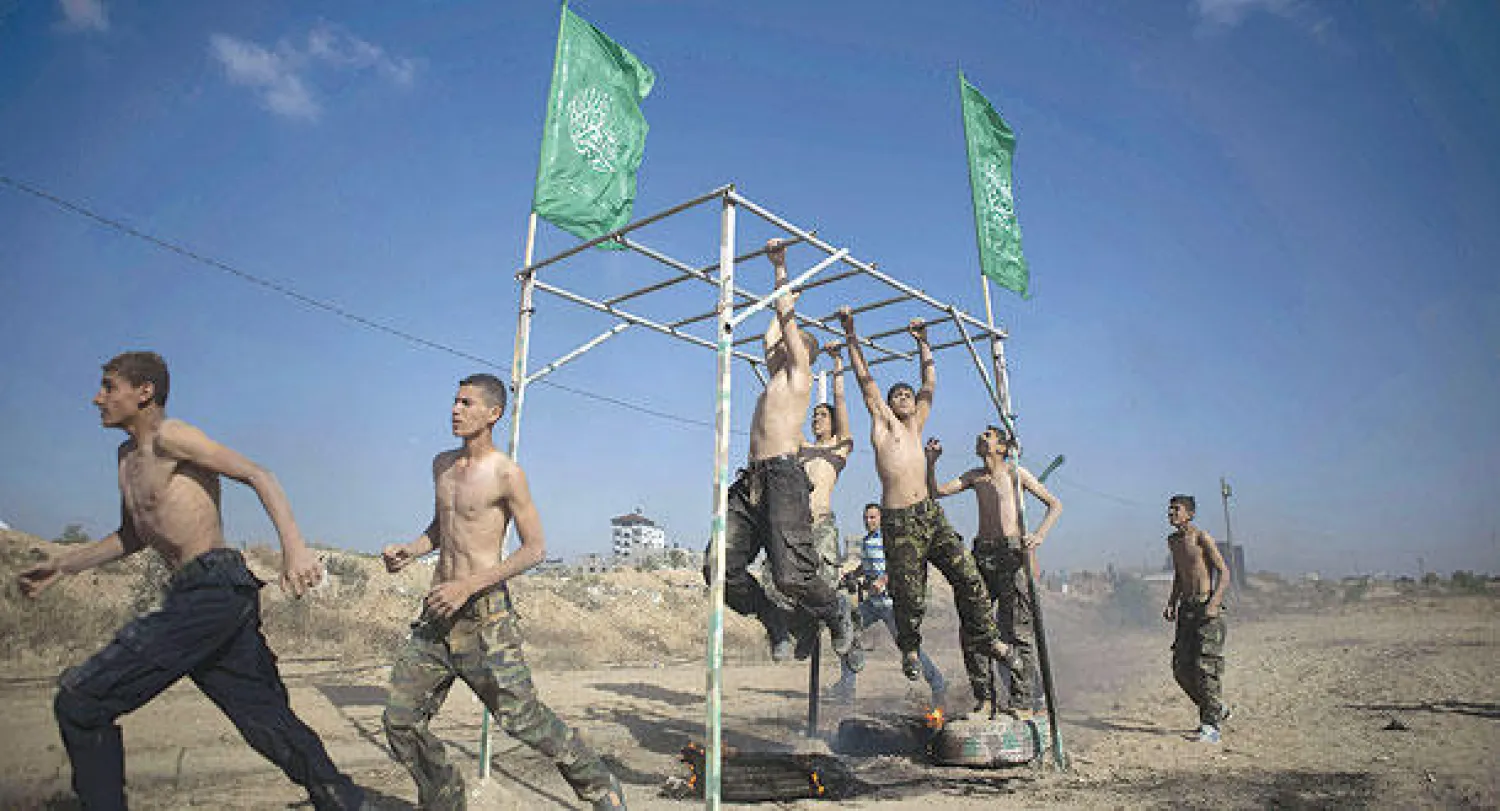 شباب فلسطينيون يتدربون في معسكر صيفي نظمته حماس في مدينة رفح بقطاع غزة أمس (أ.ف.ب)