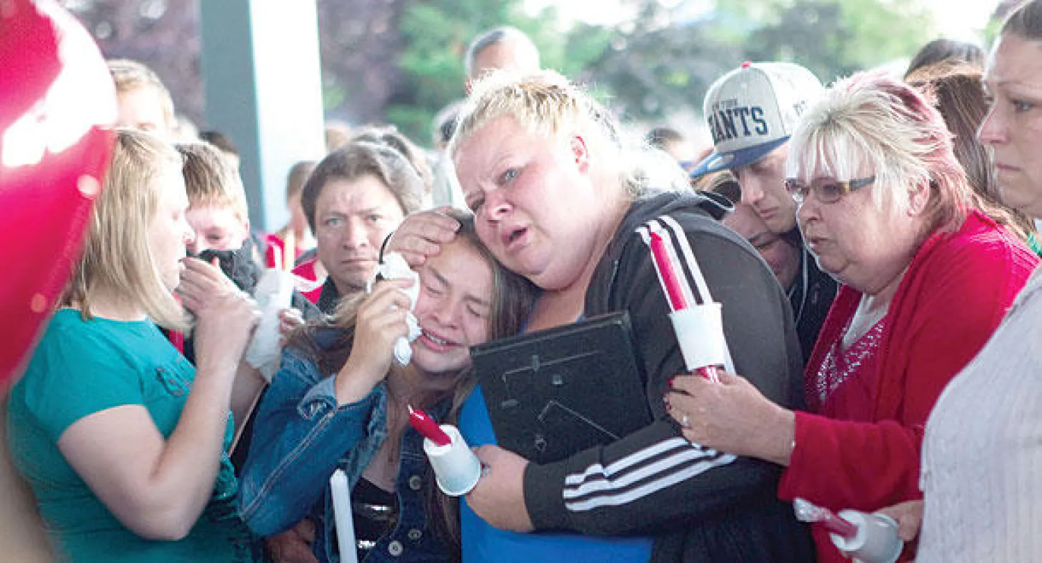 أقارب الطالب القتيل إيميليو هوفمان يبكونه في تراوتديل بمدينة بورتلاند مساء أول من أمس بعد حادثة إطلاق النار (أ.ف.ب)